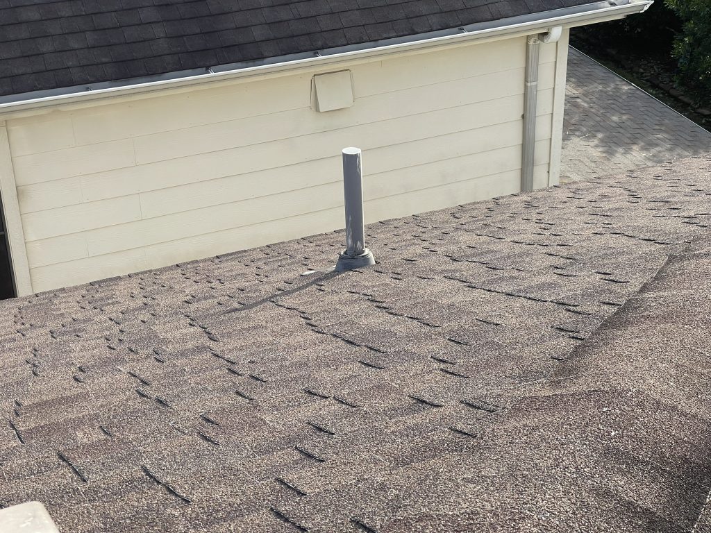 Roof inspection in Montgomery Roof inspection in Montgomery County TX with Handnail Roofing technician checking shingles from a ladder