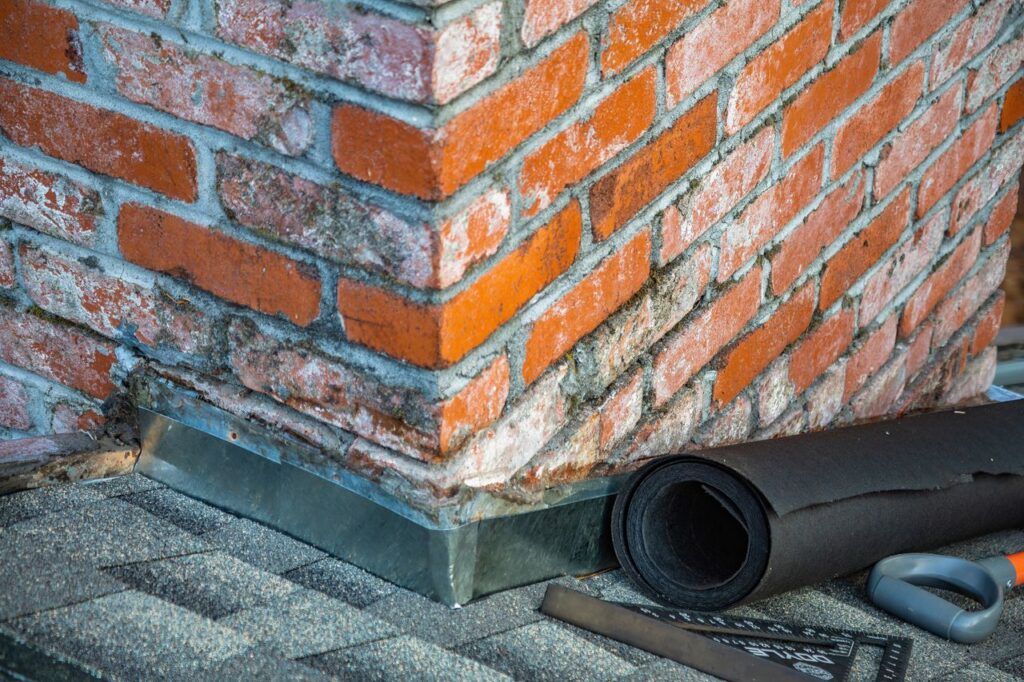 Roofing professional inspecting chimney flashing before roof replacement in Magnolia Texas.