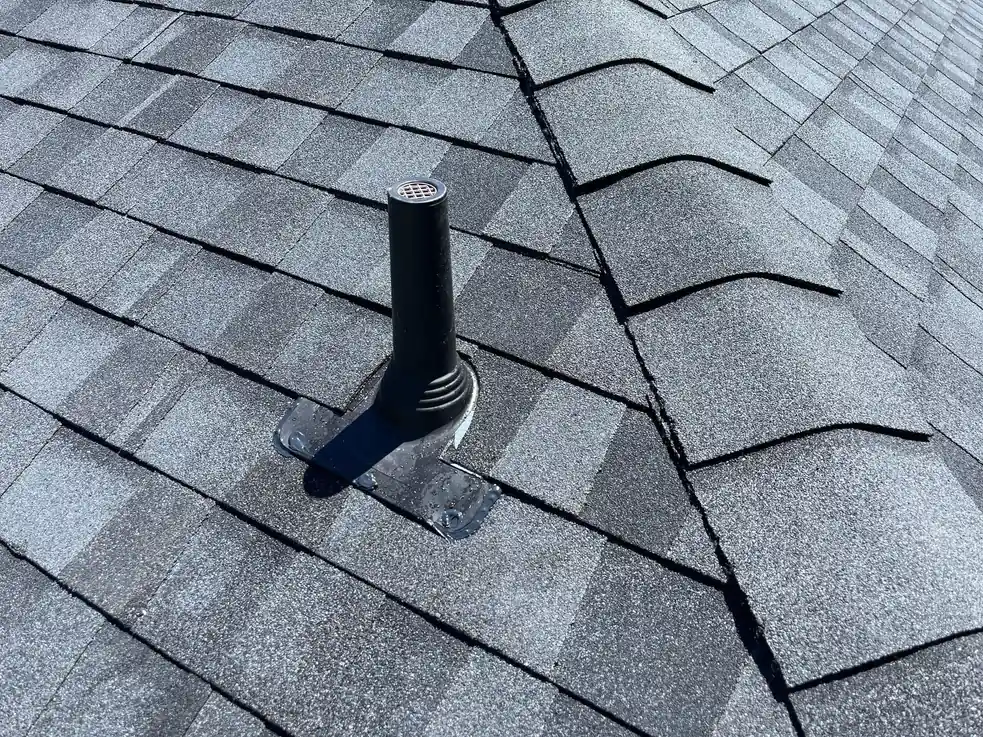 Close-up of new gray architectural shingles, hip cap and pipe boot on a roof replacement in Conroe, TX, by Handnail Roofing